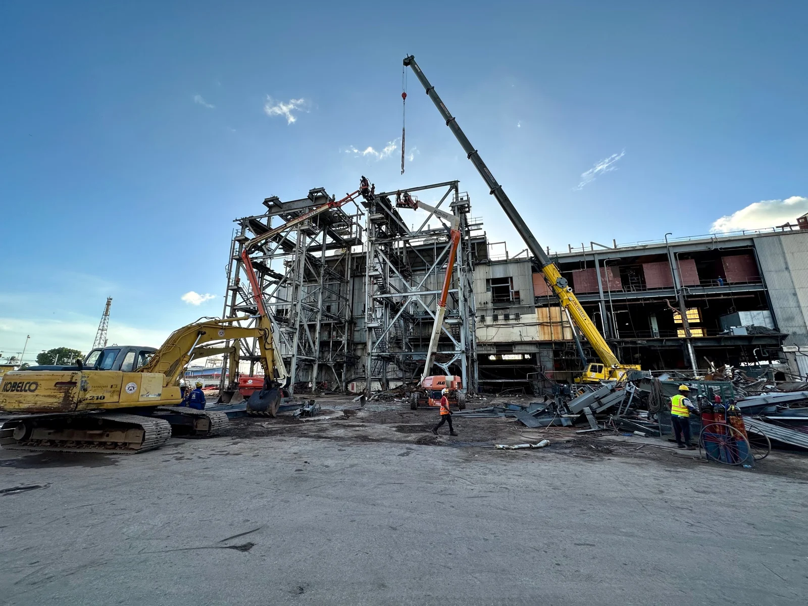 Cranes and excavators dismantling an industrial facility